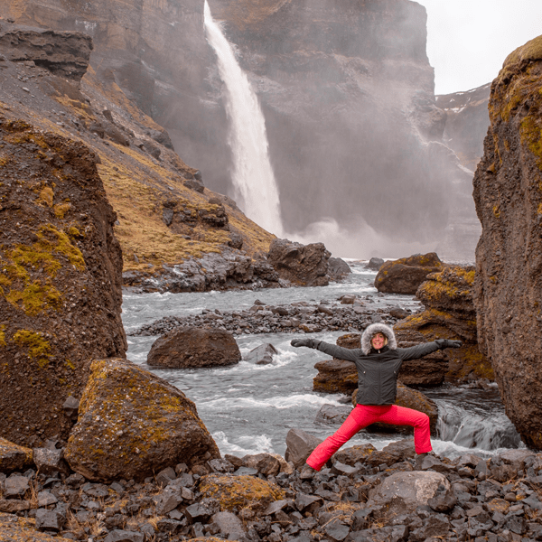 Warrior two pose riverside on this yoga retreat in Iceland with The Travel Yogi.