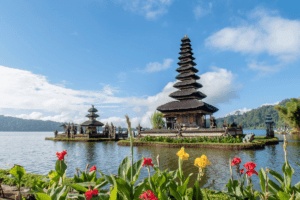Image of a Balinese temple with colorful flowers in the foreground. Learn Balinese Temple etiquette: The Travel Yogi