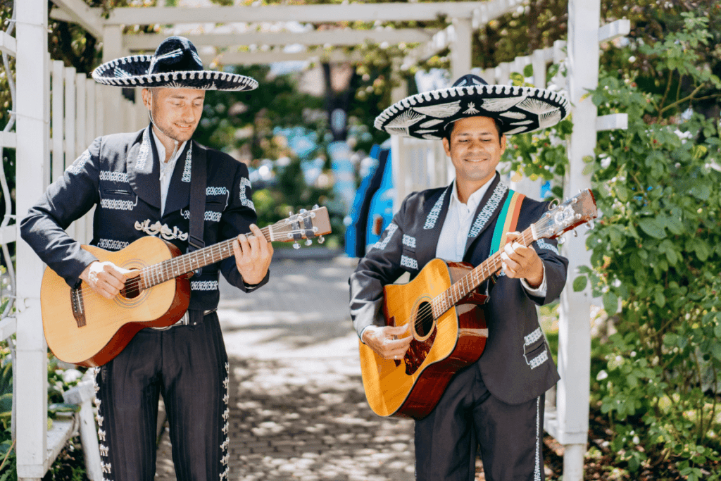 Two mariachis playing guitar. Check out these fun Spanish phrases for your next trip to Mexico with the Travel Yogi.