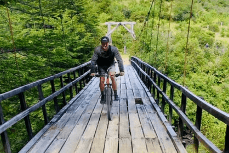 A biker rides across a wooden bridge in the jungle. Leading lines are one smart travel photography tip.