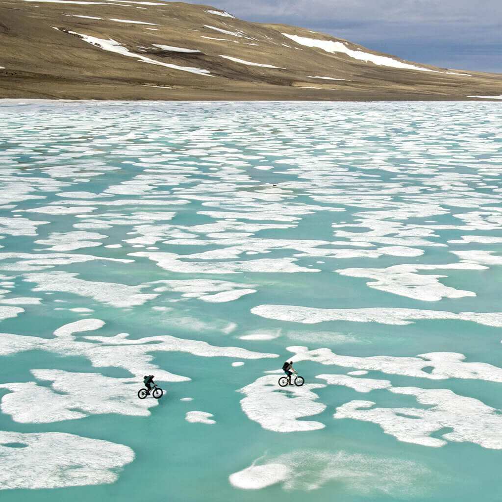 Two people bike the ice flows in the Arctic
