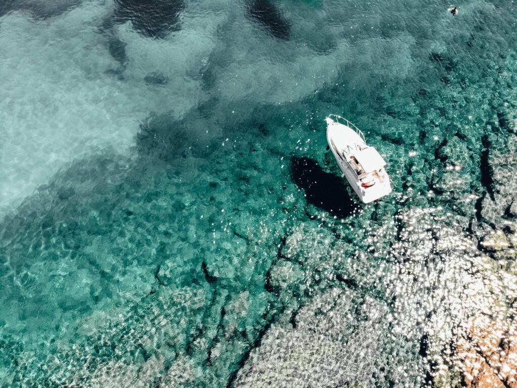 Aerial photo of a boat in the waters near Dubrovnik, Croatia by Inera Isovic via Unsplash.
