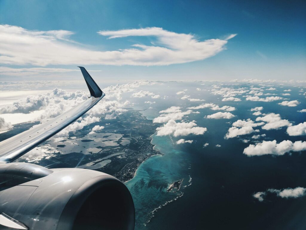 Flying on a jetplane over the clouds by Patrick Tomasso via Unsplash.