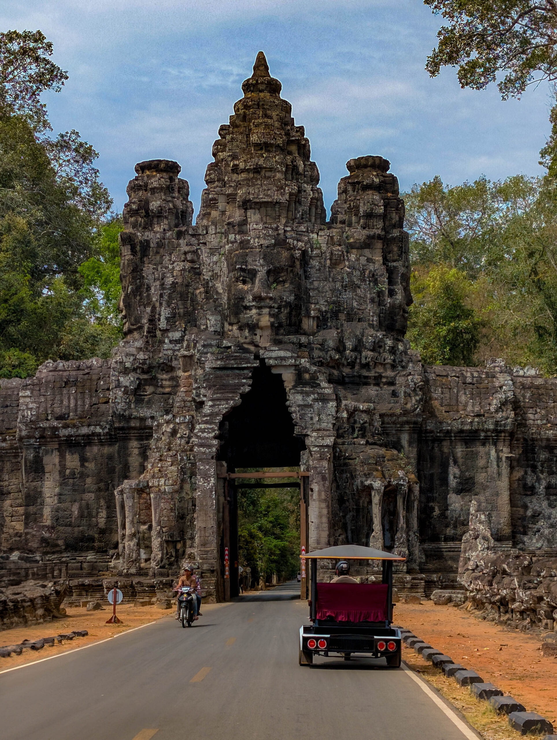 View from outside the Angkor Thom gates, wiht an old vehicle parked just in front. 